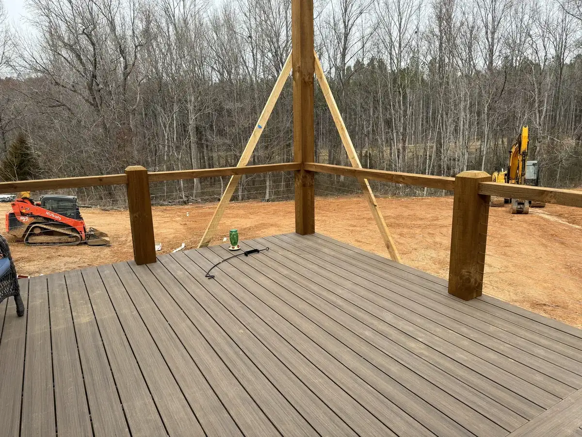 Composite deck with cable railing on a Hart Homes job site after grading